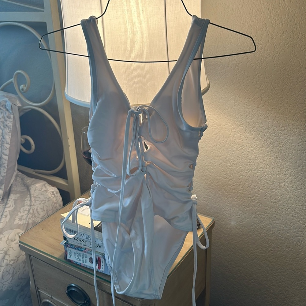 White swimsuit with ties on side and in front. Lined.